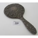 A heavily embossed modern silver hand mirror having mask, bird and foliate design, bevelled glass,