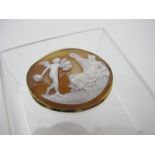 An unmarked yellow metal framed carved cameo brooch, depicting a classical figurative scene.
