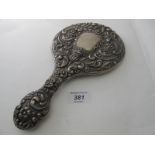 A heavily embossed silver hand mirror decoration with flowers and scrolls, Birmingham 1903.