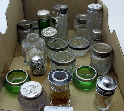 A collection of mainly silver top scent bottles, a collection of cut glass silver rimmed salts,