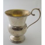 A plain silver thistle shaped christening mug on pedestal base, gilded interior, Birmingham 1923,