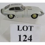 A vintage cast metal Japanese table top cigarette lighter in the form of an e-type Jaguar coupé,