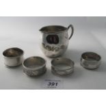 A collection of four silver napkin rings, all fully hallmarked, a sterling marked cream jug,