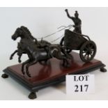 A finely cast bronze of a Roman Charioteer mounted on a red marble and black slate plinth with