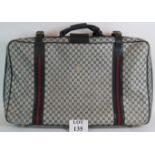 A vintage Gucci suitcase with navy and grey lattice logo designs. Size: 78cm x 44cm x 20cm.