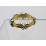 An 18ct yellow gold ring set with white gold crosses. Approx 6 grams, size M.
