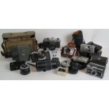 A collection of vintage 35mm cameras and lenses including Yashica, Pentax, Olympus and Vivitar,