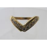 An 18ct yellow gold ring, set with a band of nine diamonds in a 'V' shape design, size M.