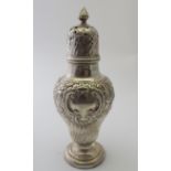 A weighted embossed silver caster of baluster form with pierced dome cores, plain cartouche,