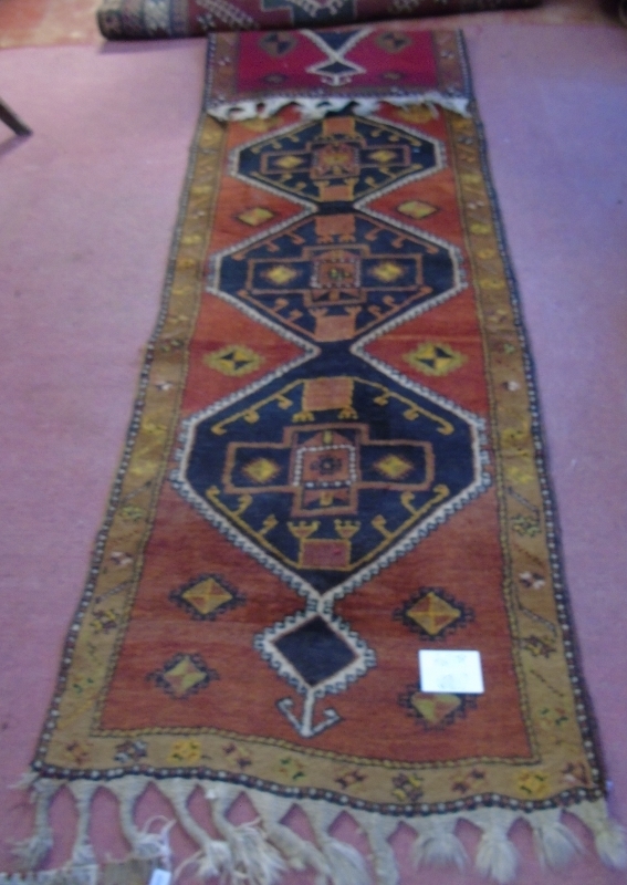 An early-mid 20's Turkish runner with repeated central motif on a red ground and tan border. - Image 2 of 4