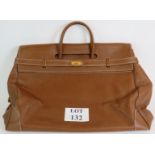 A large high quality grained chestnut hide leather over night holdall with gilt fittings and