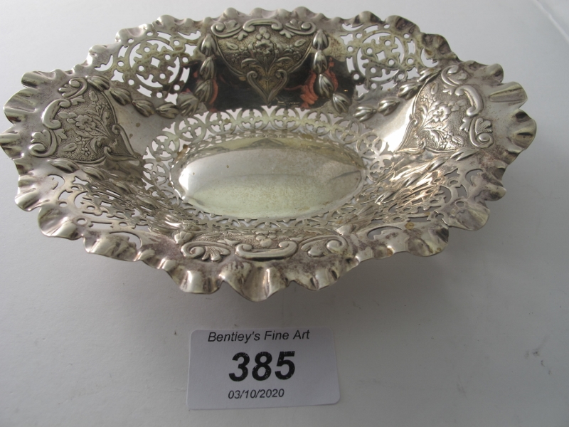 An oval shaped silver bon bon dish with pierced decoration and embossed with panels,