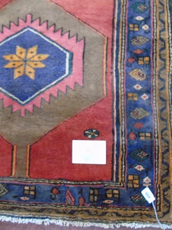 A Hamadan rug with central motif on red ground. 1.72 x 95 Condition report: In very good condition.