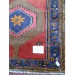 A Hamadan rug with central motif on red ground. 1.72 x 95 Condition report: In very good condition.