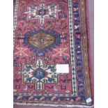 A good Karajeh rug with central motifs on red ground. 1.88 x 0.84.