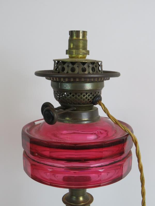 An antique Cranberry glass oil lamp later converted to electricity, with black porcelain base. - Image 2 of 4