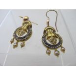 A pair of unmarked yellow metal drop earring,