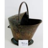 An antique copper helmet shaped coal bucket with decorated top. Height of bucket 36cm.