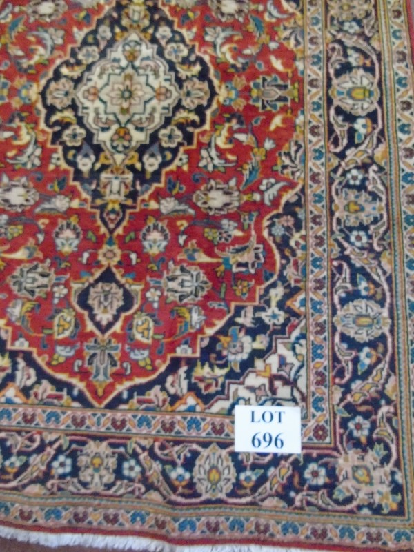 A Persian rug with central pattern on red ground, 146cm x 108cm.