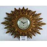 A Smiths 8 day sunburst clock with gilt plaster surround and mechanical movement. C1930's.