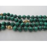 A malachite bead necklace with eight interspersed gold coloured beads, approx 32" long.