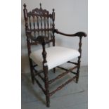 A pretty mahogany framed elbow chair with decorative turned supports and stretchers over a cream