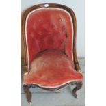 A Victorian show wood armchair upholstered in a pink velvet material.