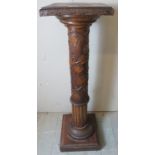 A 19th Century oak torchere stand carved with flowering vines.