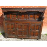 A large oak court cupboard with a carved frieze bearing carved date '1672' over bulbous carved