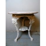 A vintage wrought iron pub table with a limed circular top over a white painted base with cast