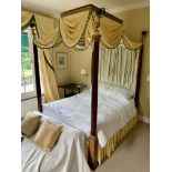 A Georgian design flamboyant four poster double bed with reeded mahogany columns beneath an