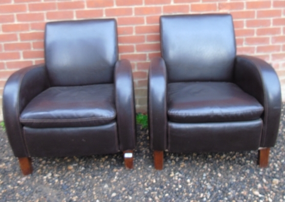 A pair of 20th Century brown leather lounge armchairs in good condition.