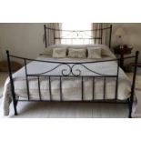 A bespoke wrought iron super king size bed complete with side rails and wooden base slats.