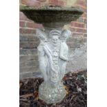 A cast garden bird bath with a dished top over a figural moulded column.