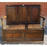 A rustic 18th Century panelled oak settle with a lift up storage area to seat.