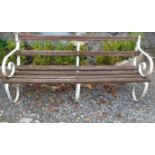 A vintage slatted wooden garden bench with decorative white painted scroll ends.