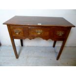 A Georgian oak lowboy with three frieze drawers over chamfered square legs with brass handles.