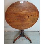 A Georgian circular tilt top table with a turned column and splayed feet.