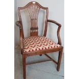 A Georgian design open-sided elbow chair with carved back over an upholstered seat.