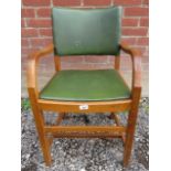 A 20th Century desk chair with green leatherette upholstered back and seat pad over lower