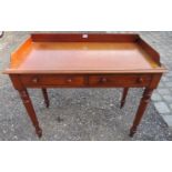 A Victorian mahogany writing desk with a raised carved gallery rail over two small drawers and