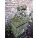 An impressive Chilstone garden statue of two cradling cherubs on a sectional plinth base.