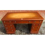 A 19th Century mahogany pedestal desk with an inset tooled tan leather top over an assortment of