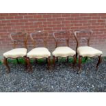 Set of four Victorian walnut balloon back dining chairs with cream upholstery to seats.