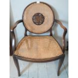 An early 20th century mahogany framed Bergere elbow chair with ornate back panel.