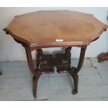 An Edwardian light mahogany center / lamp table with carved legs and unusual design shelf.