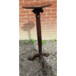 A 20th Century mahogany torchere stand with a fluted column over splayed legs.