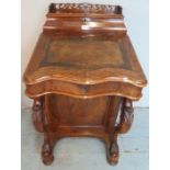 A Victorian walnut davenport with a carved gallery rail over a fitted stationary compartment to top