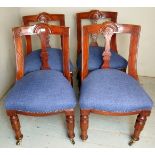 A set of four 20th Century carved mahogany framed dining chairs upholstered in a deep blue material