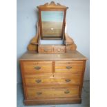 An Edwardian oak dressing table with a central mirror over two small drawers to top,